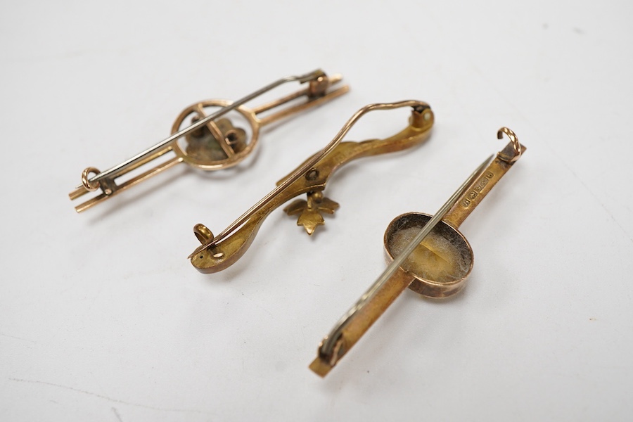 An Edwardian 15ct gold and seed pearl set foliate bar brooch, 41mm, together with a 9ct gold and gem set bar brooch and one other yellow metal and gem set bar brooch.